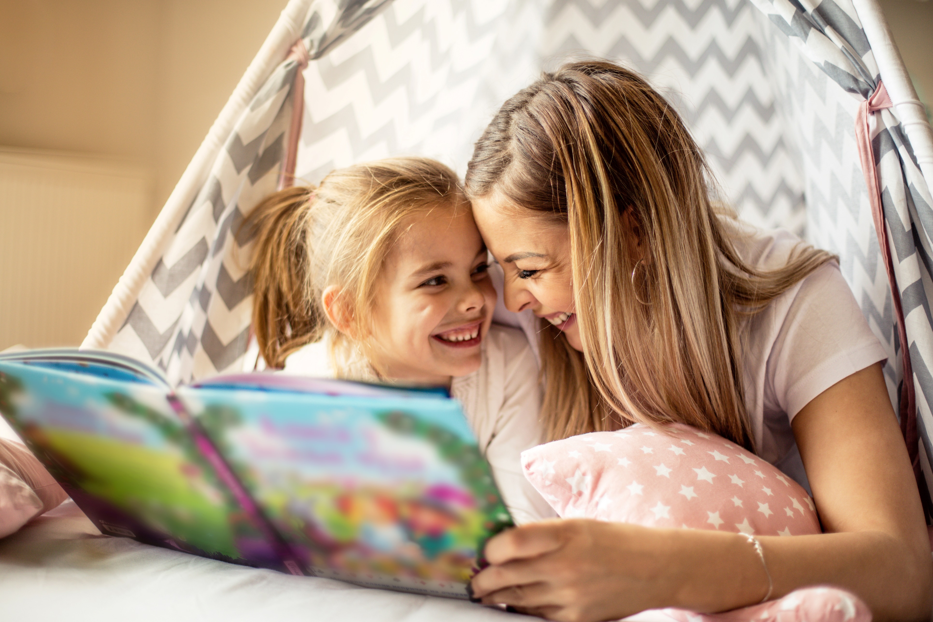 Mutter und Tochter lesen zusammen in einem Kinderbuch