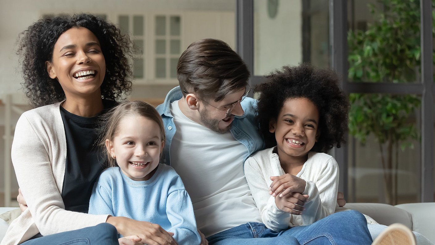 Lachende Eltern genießen Fernseh gucken mit den Kindern 