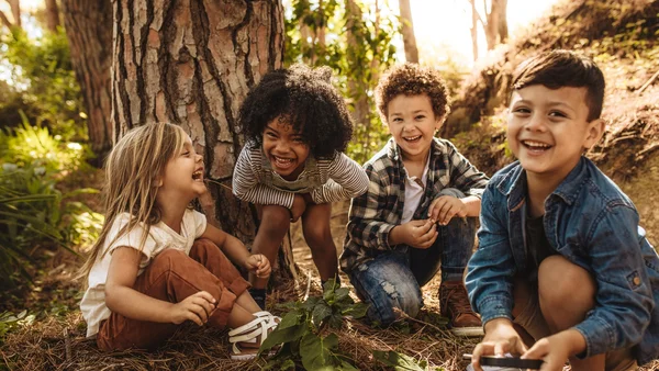 Gruppe von Kindern die im Wald spielen