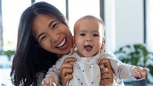 Mutter_und_Baby_kuscheln_fröhlich_im_Bett