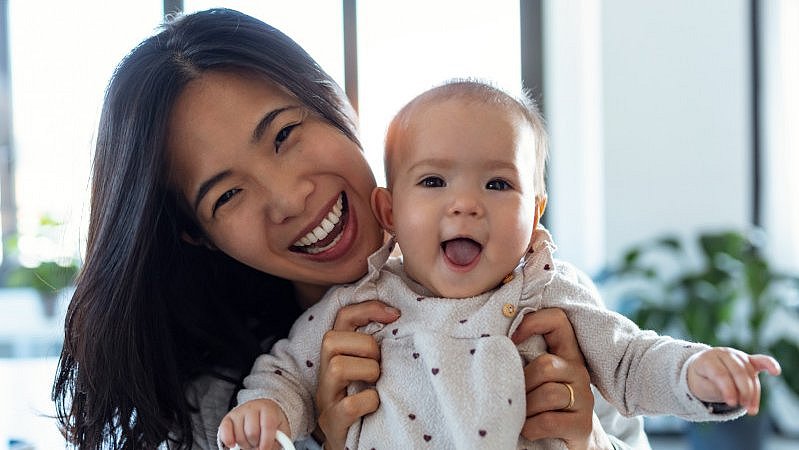 Mutter_und_Baby_kuscheln_fröhlich_im_Bett