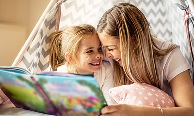 Mutter und Tochter lesen zusammen in einem Kinderbuch