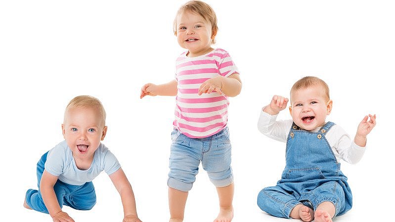 Drei Kinder krabbeln, sitzen und stehen