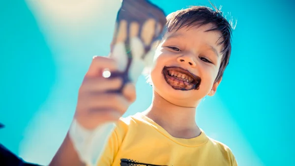 Ein_Junge_mit_eisverschmiertem_Gesicht_hält_ein_Waffeleis