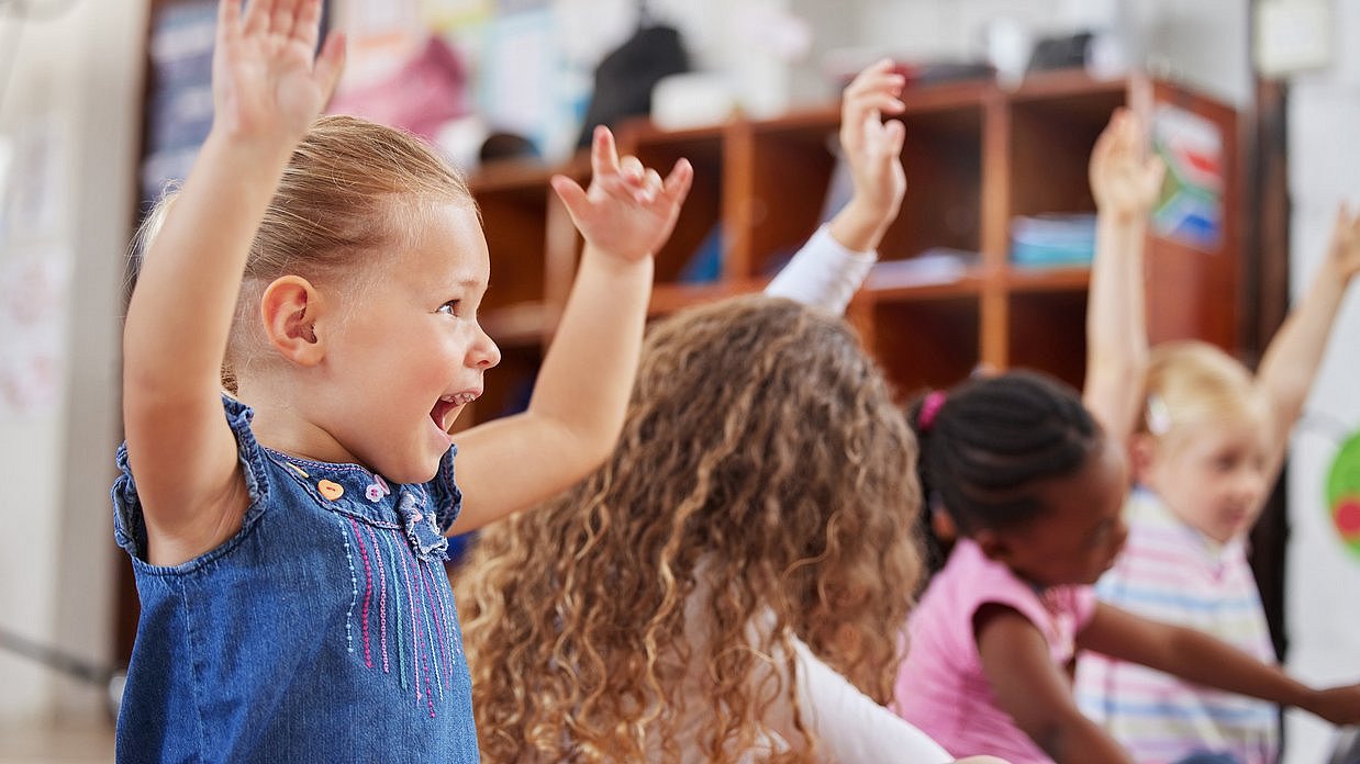 Kinder heben die Arme nach oben