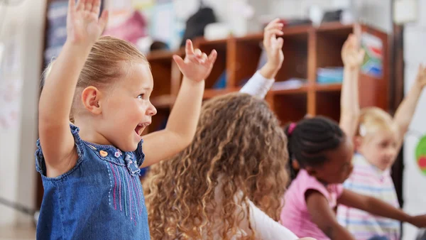 Kinder heben die Arme nach oben