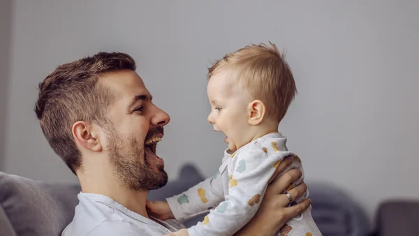 Vater und kleiner Junge lachen sich an