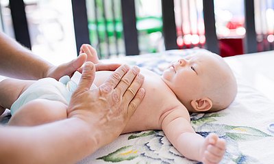 Babys Bauch wird massiert