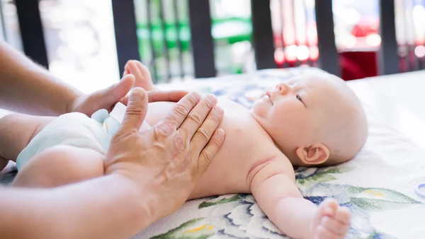 Babys Bauch wird massiert