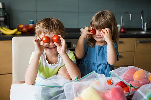 Zwei_Kinder_halten_Tomaten_vor_die_Augen
