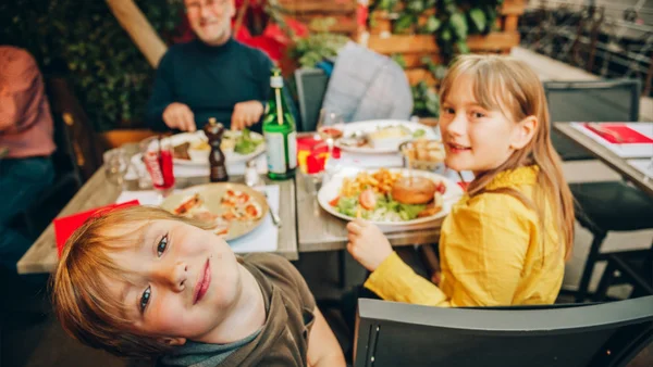 Vater_im_Restaurant_mit_zwei_Kindern_und_einer_Auswahl_an_Speisen