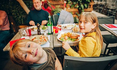 Vater_im_Restaurant_mit_zwei_Kindern_und_einer_Auswahl_an_Speisen