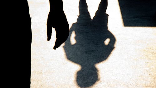 Ein bedrohlicher Schatten und das Schattenbild eines Kindes