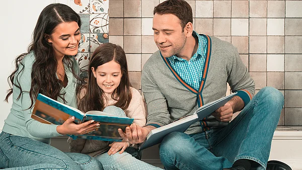 Vater und Mutter lesen mit ihrer Tochter