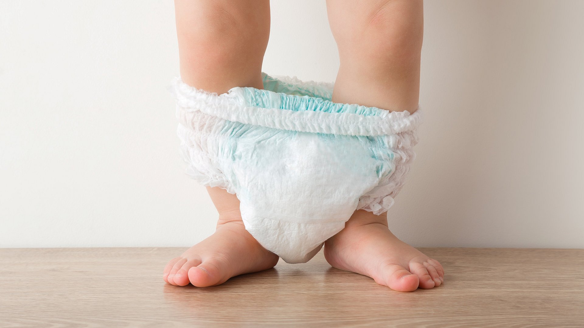 Babybeine mit Pampers zwischen den Beinen