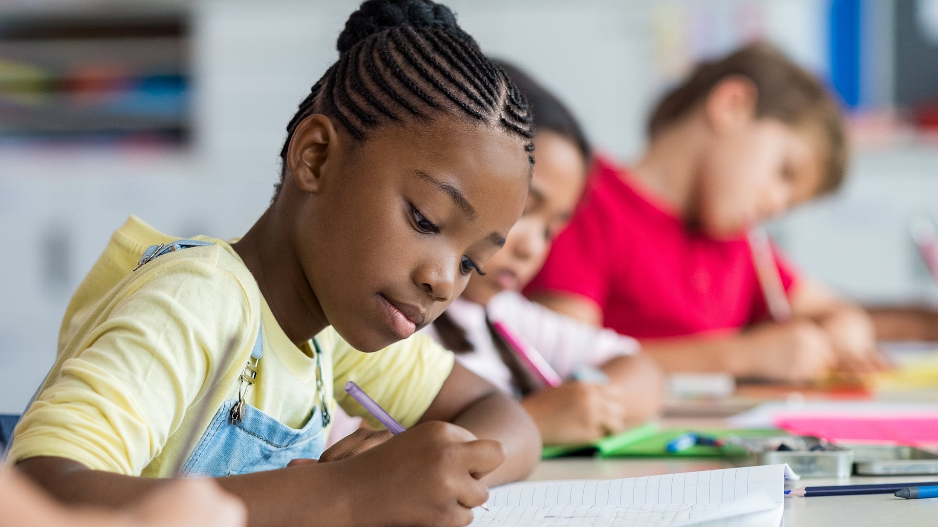 Kinder sitzen in der Schule und schreiben