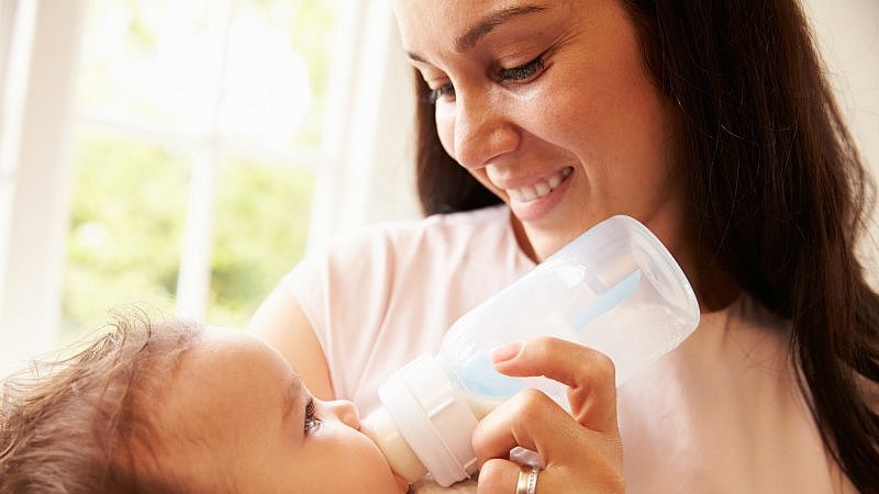 Mutter_hält_Baby_im_Arm_und_füttert_mit_Fläschchen