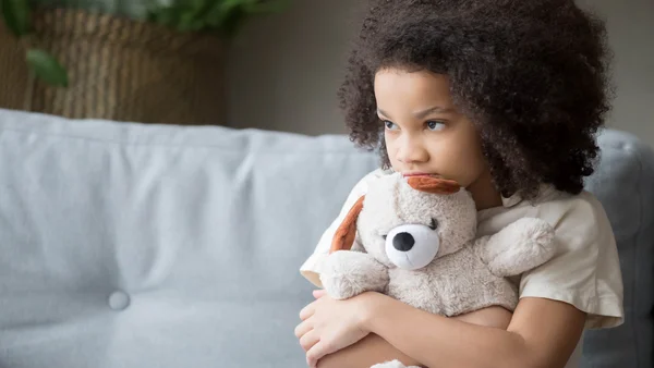 kleines Mädchen umklammert einen Teddybären
