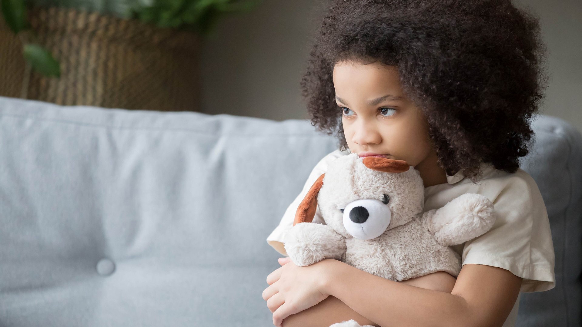 kleines Mädchen umklammert einen Teddybären