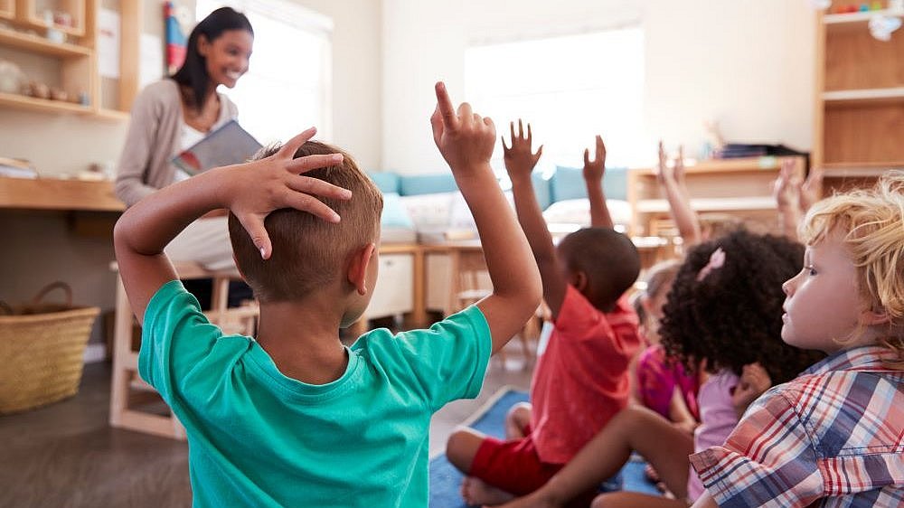 Kinder melden sich im Unterricht