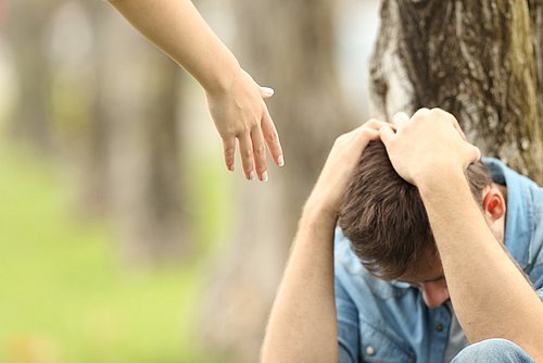 Eine helfende Hand, Jugendlicher sitzt mit Kopf in den Händen