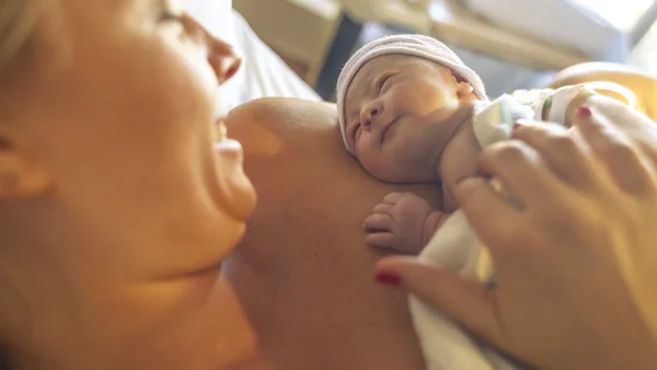 Mutter hat ihr Neugeborenes auf dem Arm