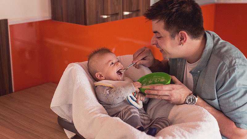 Vater_füttert_Baby_mit_Brei