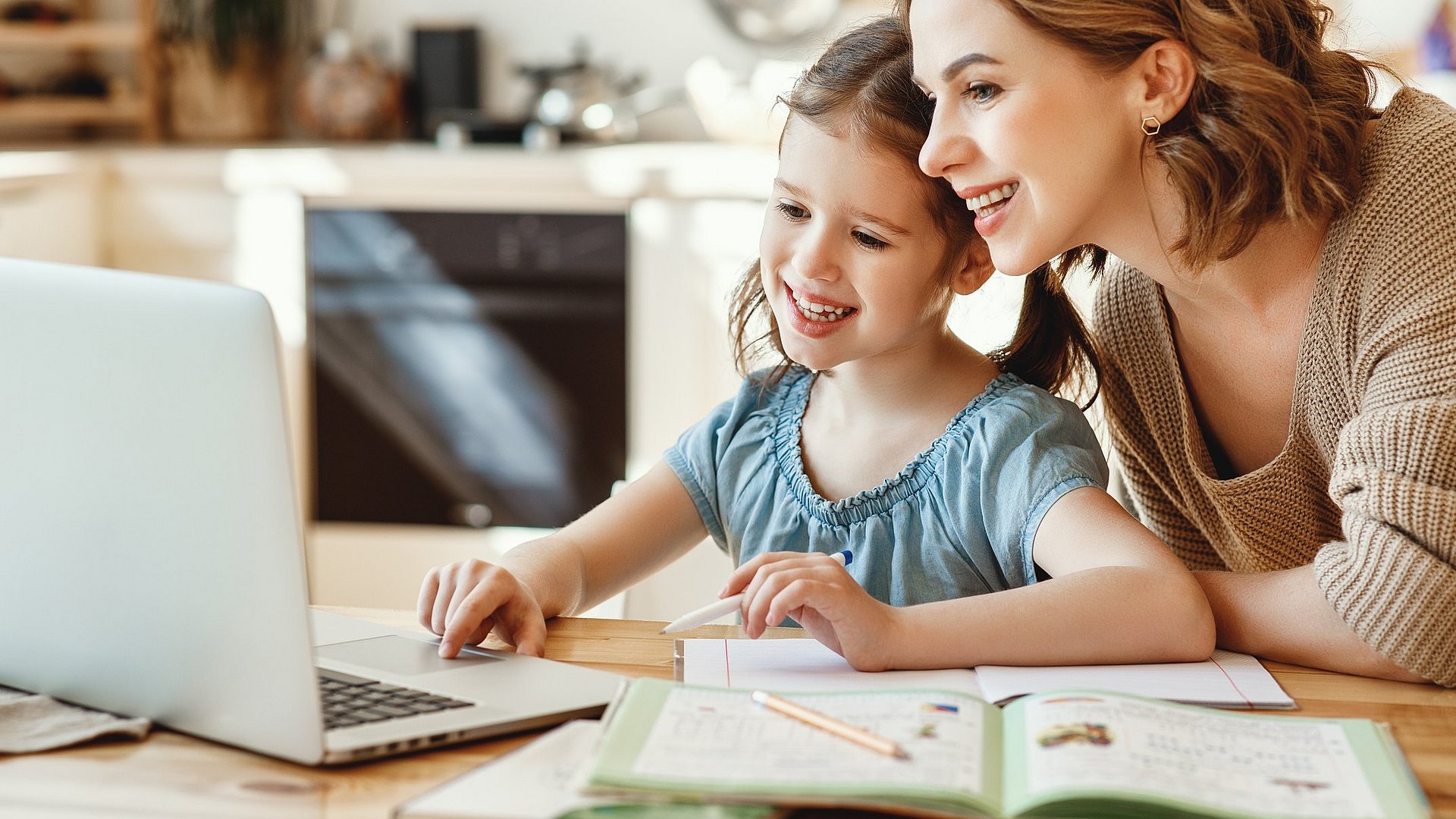 Mutter und Tochter lernen zusammen am Laptop