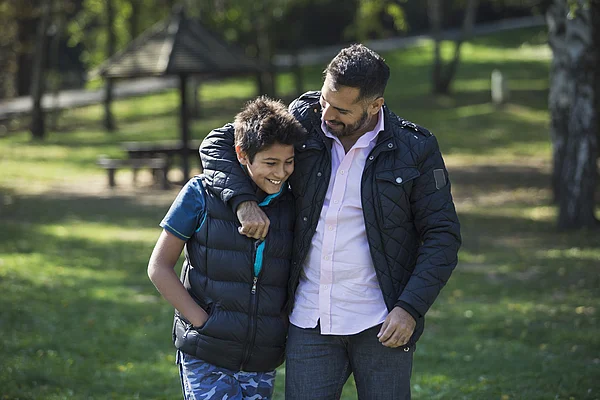 Vater umarmt Sohn im teenage alter
