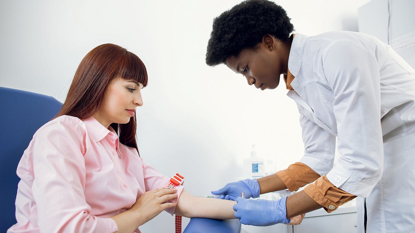 Einer Frau  wird Blut abgenommen