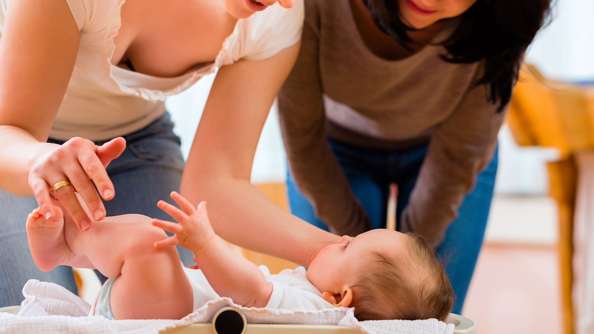 Mutter und Beraterin schauen auf Baby