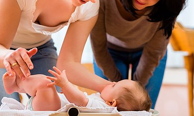 Mutter und Beraterin schauen auf Baby