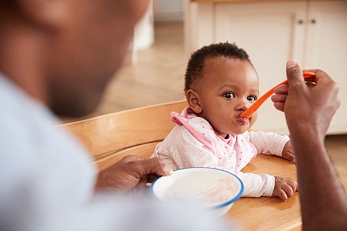 Vater_füttert_kleine_Tochter_mit_Brei