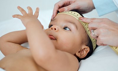 Baby mit Messband um den Kopf