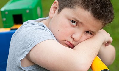 korpulenterer Junge mit traurigem Blick