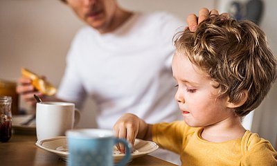Kind_fruehstueckt_mit_Vater_am_Tisch