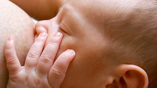 Baby trinkt von der Brust der Mutter