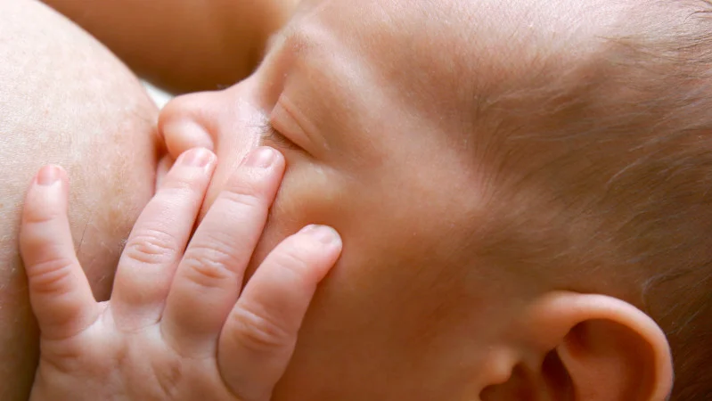 Baby trinkt von der Brust der Mutter