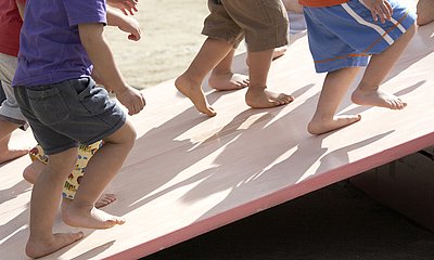 Kinderfüsse gehen eine Schräge hoch