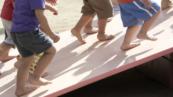 Kinderfüsse gehen eine Schräge hoch